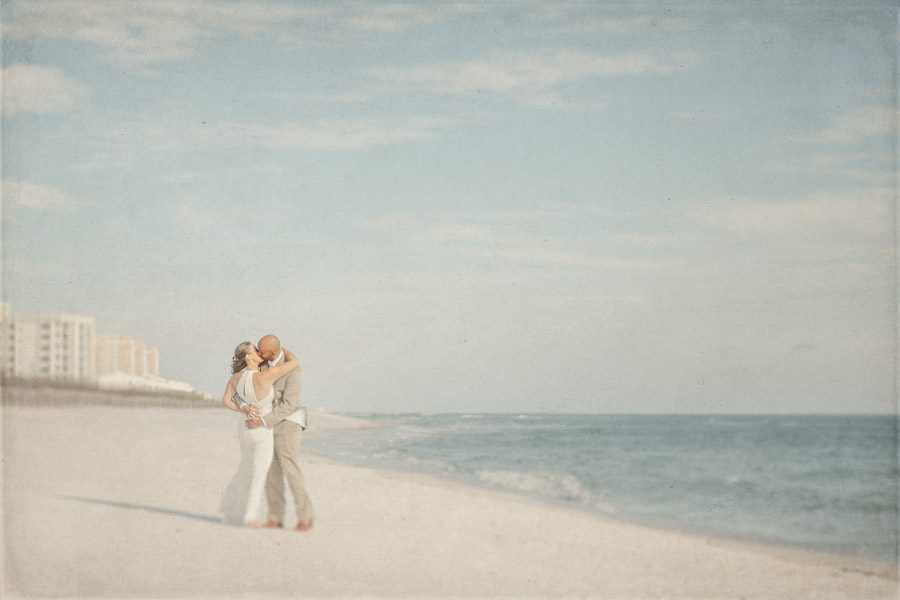 Newlyweds kiss on beach at Florida destination wedding