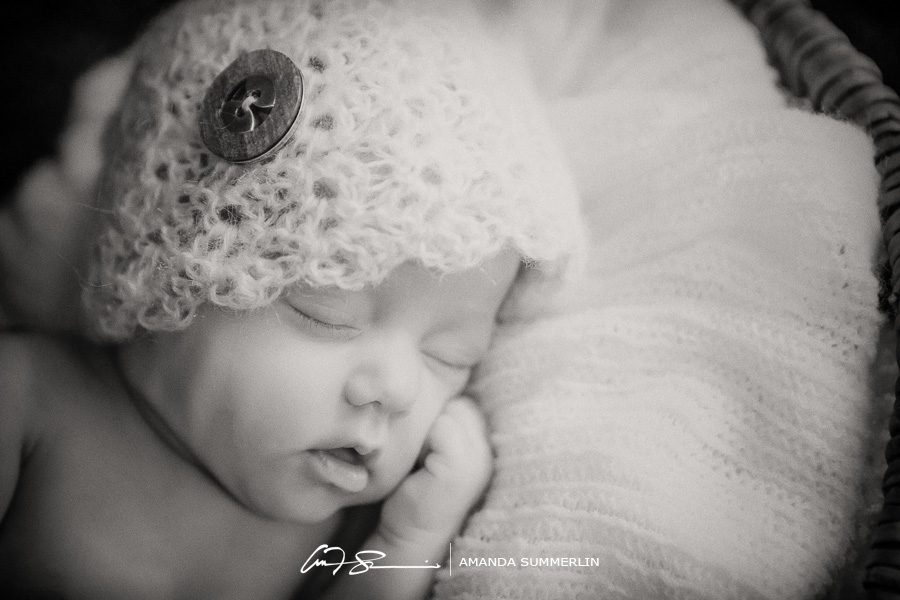 Black and white photo of newborn in lacy bonnet