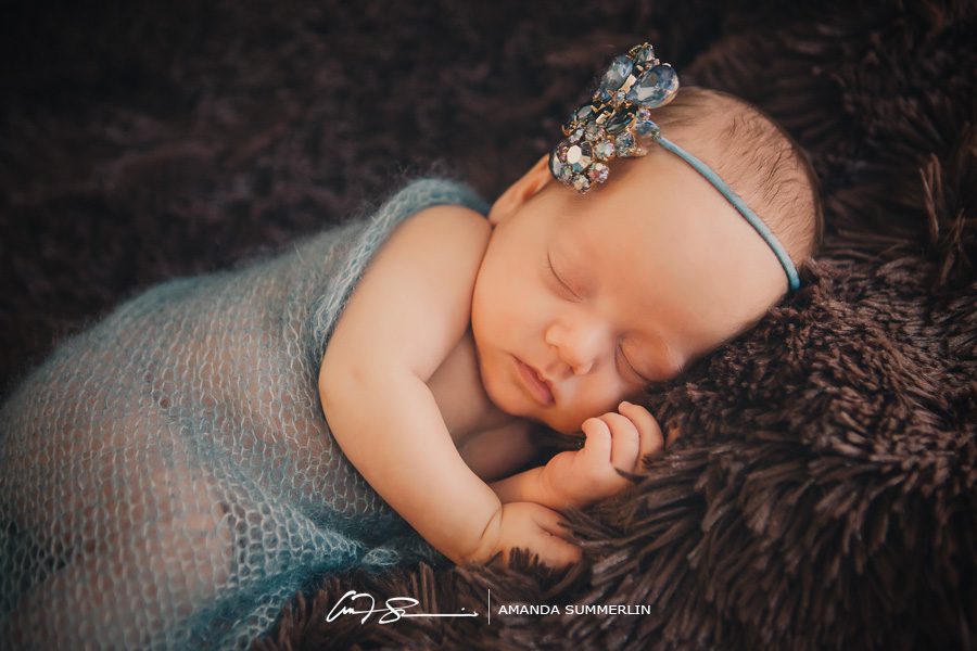 Portrait of newborn baby girl with blue jeweled head band