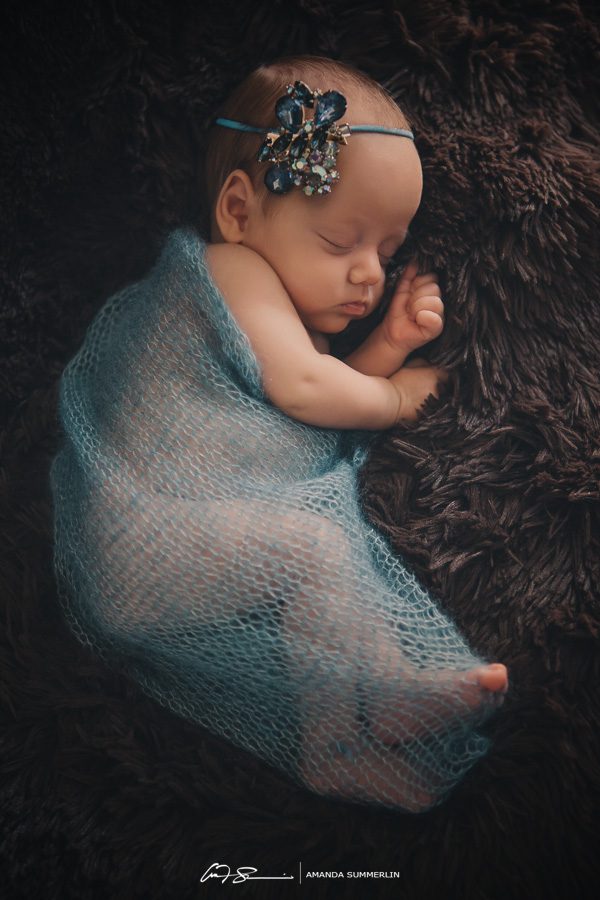 Portrait of newborn baby girl with blue jeweled head band