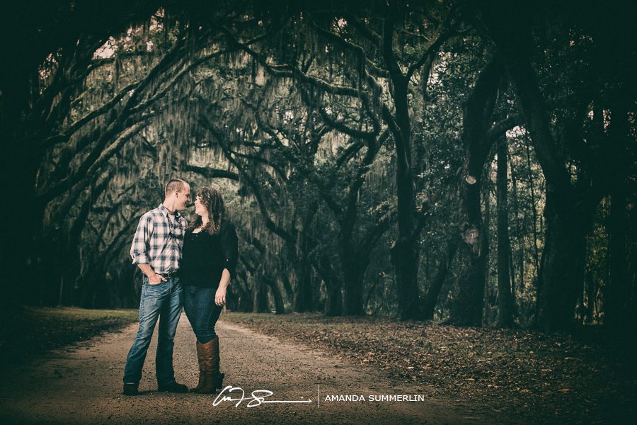 Engaged couple under the oak trees at Wormsloe Historic Plantation in Savannah