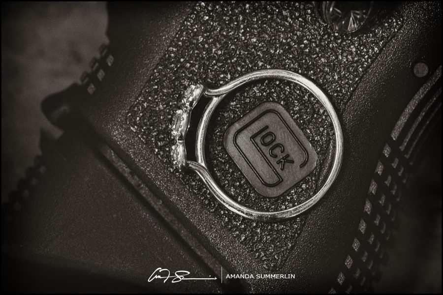 Black and white photo of engagement ring on Glock pistol