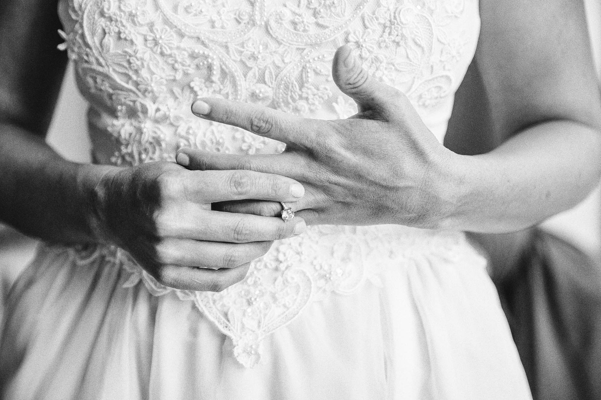 A black-and-white close-up photo of a nervous bride's hands