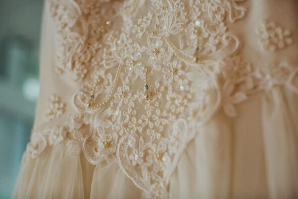 A close-up of the beads on a white wedding dress