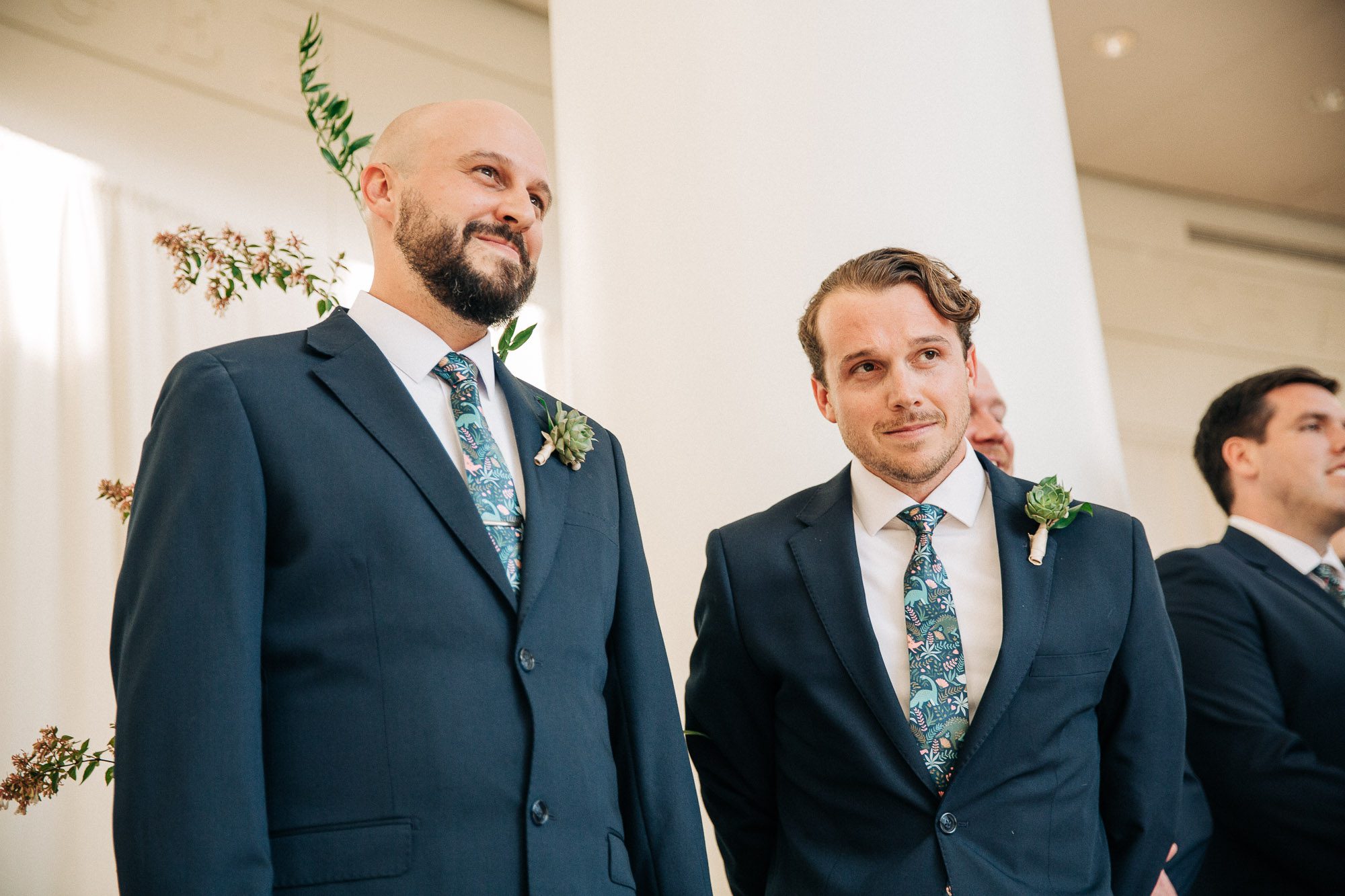 A photo of the groom and the best man as they watch the bride walk down the aisle
