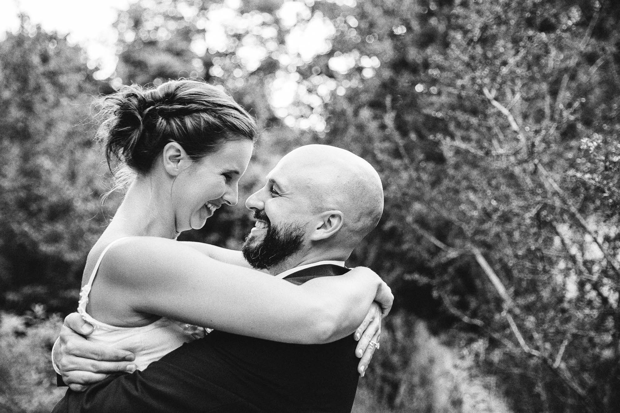 Black-and-white close-up of a bride and groom hugging
