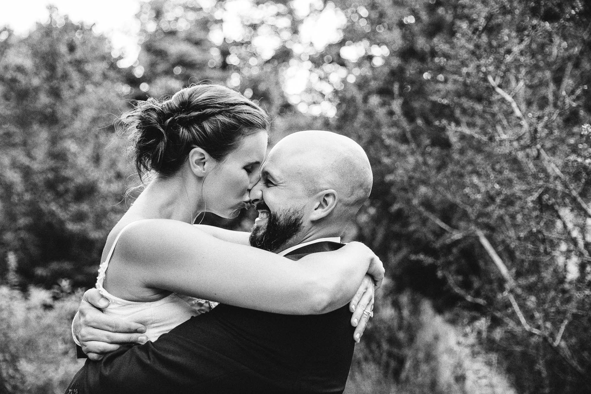 Black and white close-up photo of a bride kissing a groom