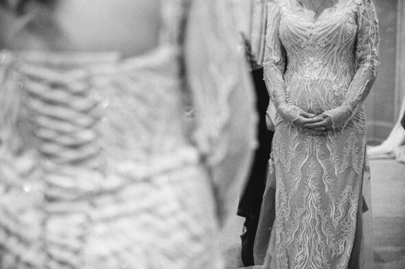 a pregnant bride wearing a white dress holds her belly