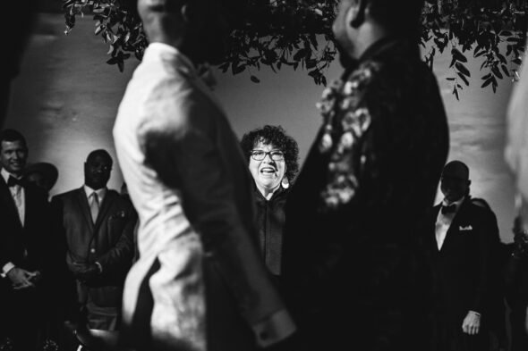 SCOTUS Sonia Sotomayor stands smiling between two grooms as she officiates their wedding