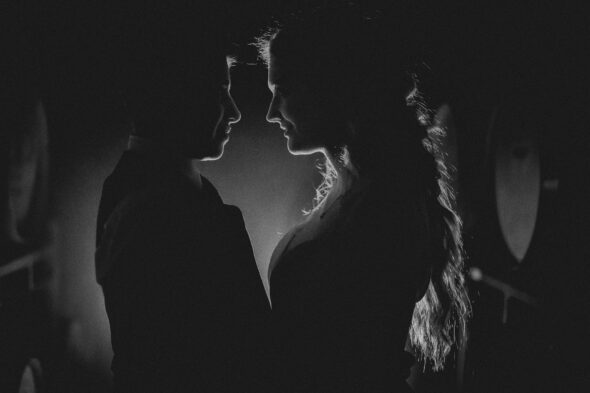 black and white photo of a couple on their wedding day in silhouette facing each other
