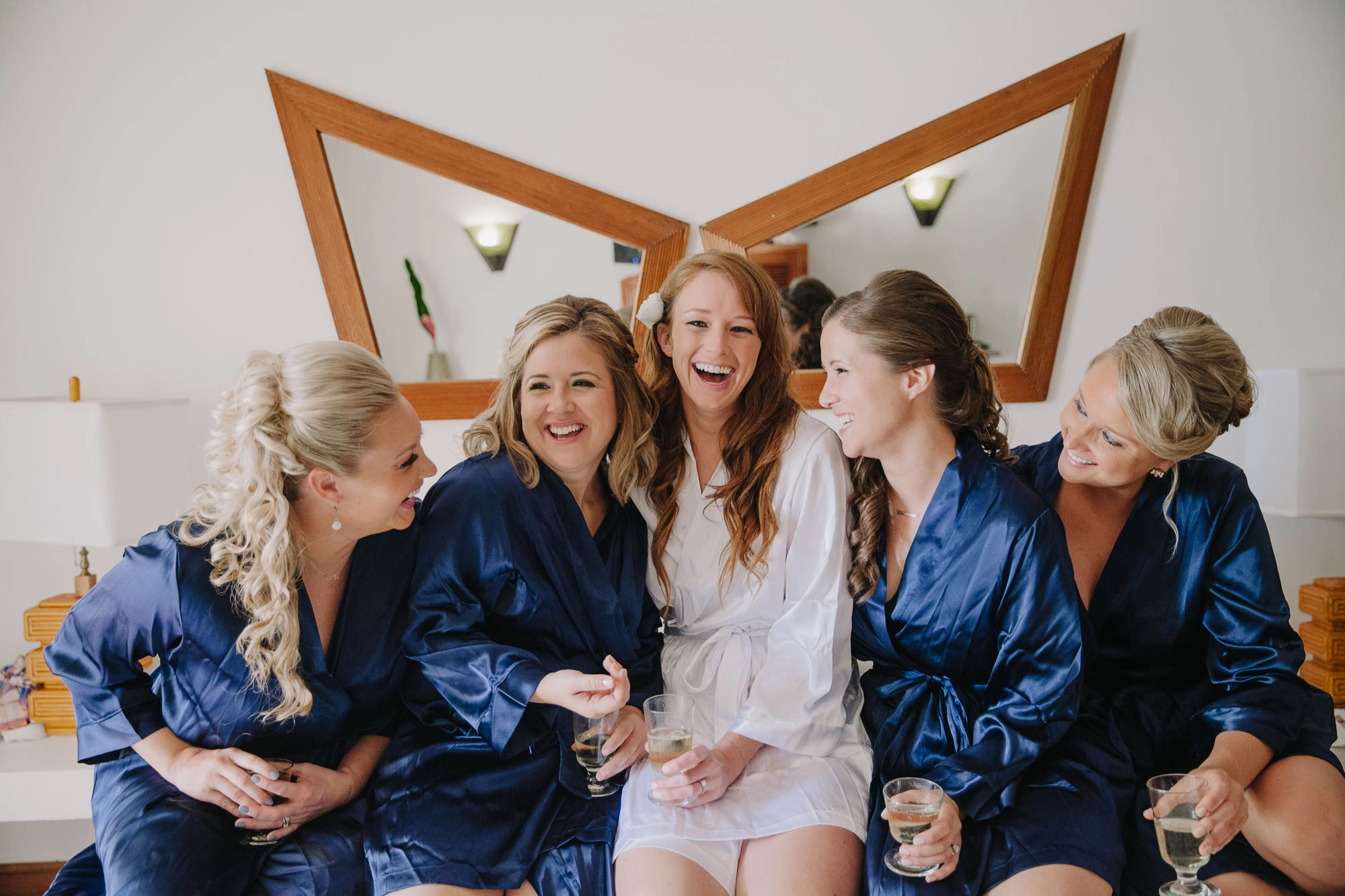 a bride and her bridesmaids share a laugh