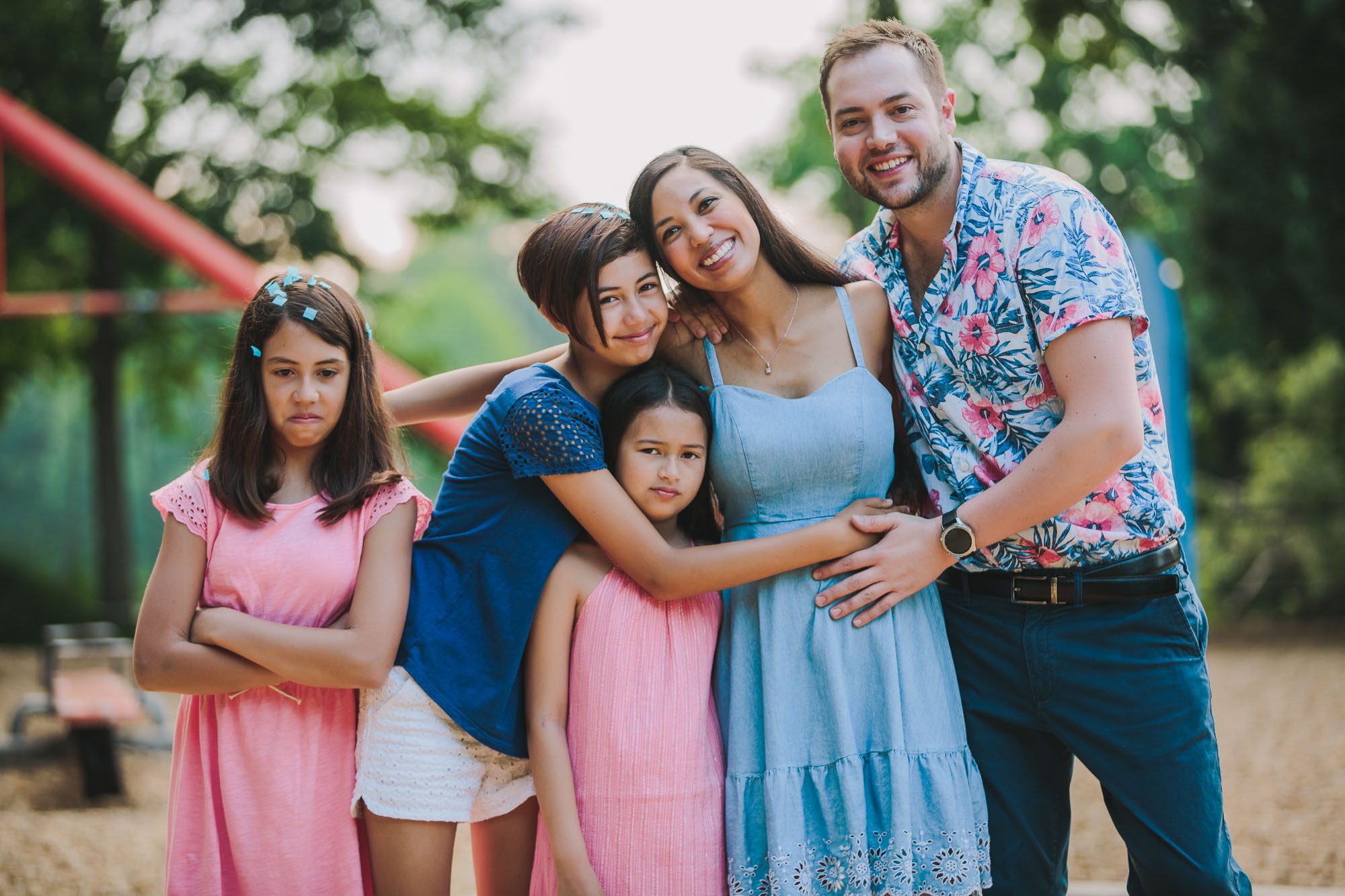a family of five embraces at the playground in Atlanta Piedmont Park