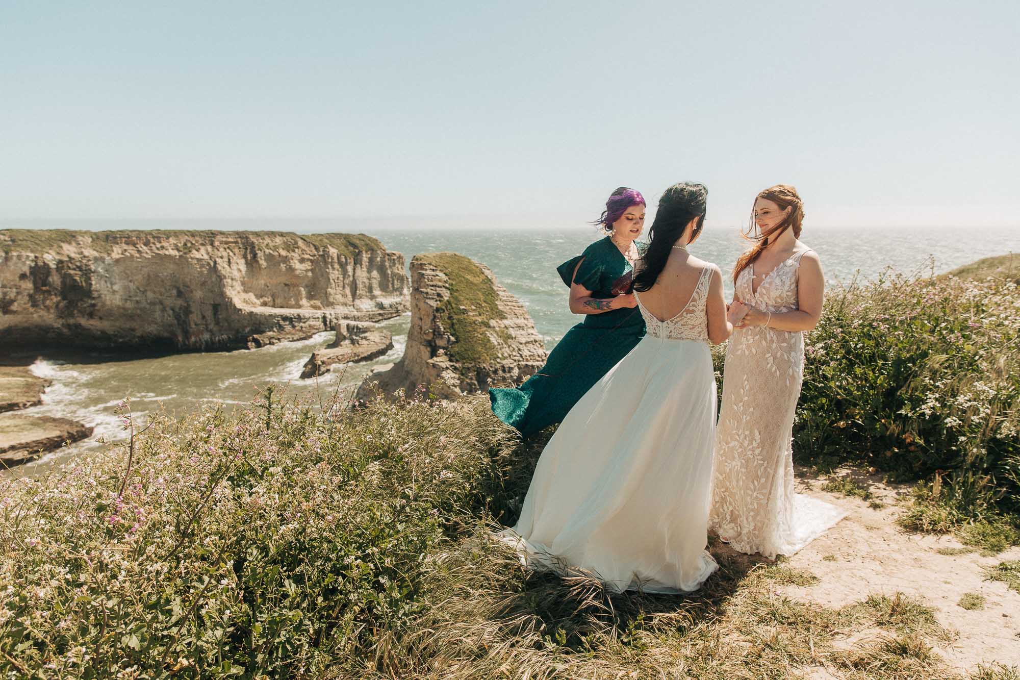 an lgbtq couple says their wedding vows on a cliff at their California coast elopement