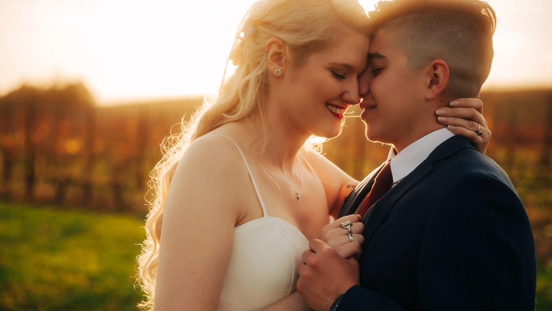 Newlywed couple embraces in the light of sunset