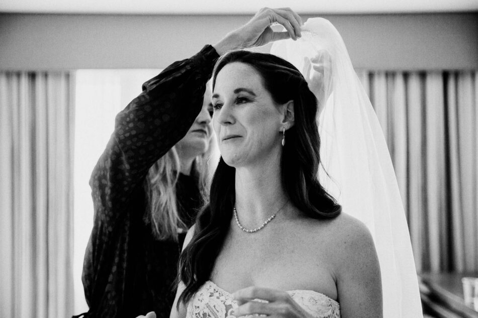 a bride puts on her veil at the Inn At Virginia Tech hotel 