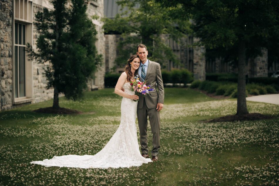 a bride and a groom stand together on the lawn of the Inn at Virginia Tech