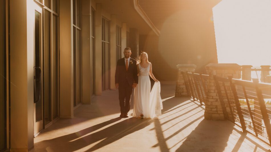 newlywed couple walks on the balcony at the lodge at guntersville state park in Alabama
