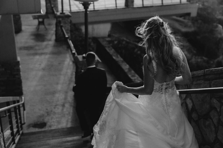 a newlywed couple walks down the stairs at the lodge at lake guntersville state park in Alabama