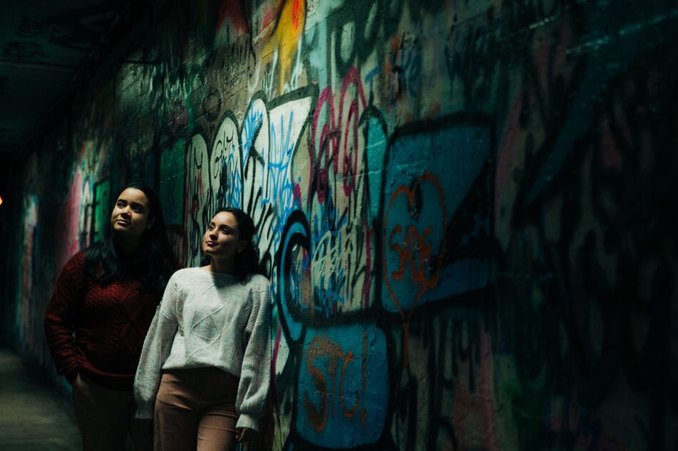 a couple leans against a wall covered in graffiti in Atlanta's Krog Tunnel for their engagement photos