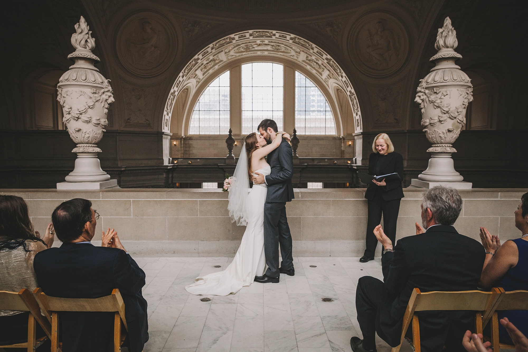 a bride and groom share their first kiss during their wedding ceremony at San Francisco City Hall