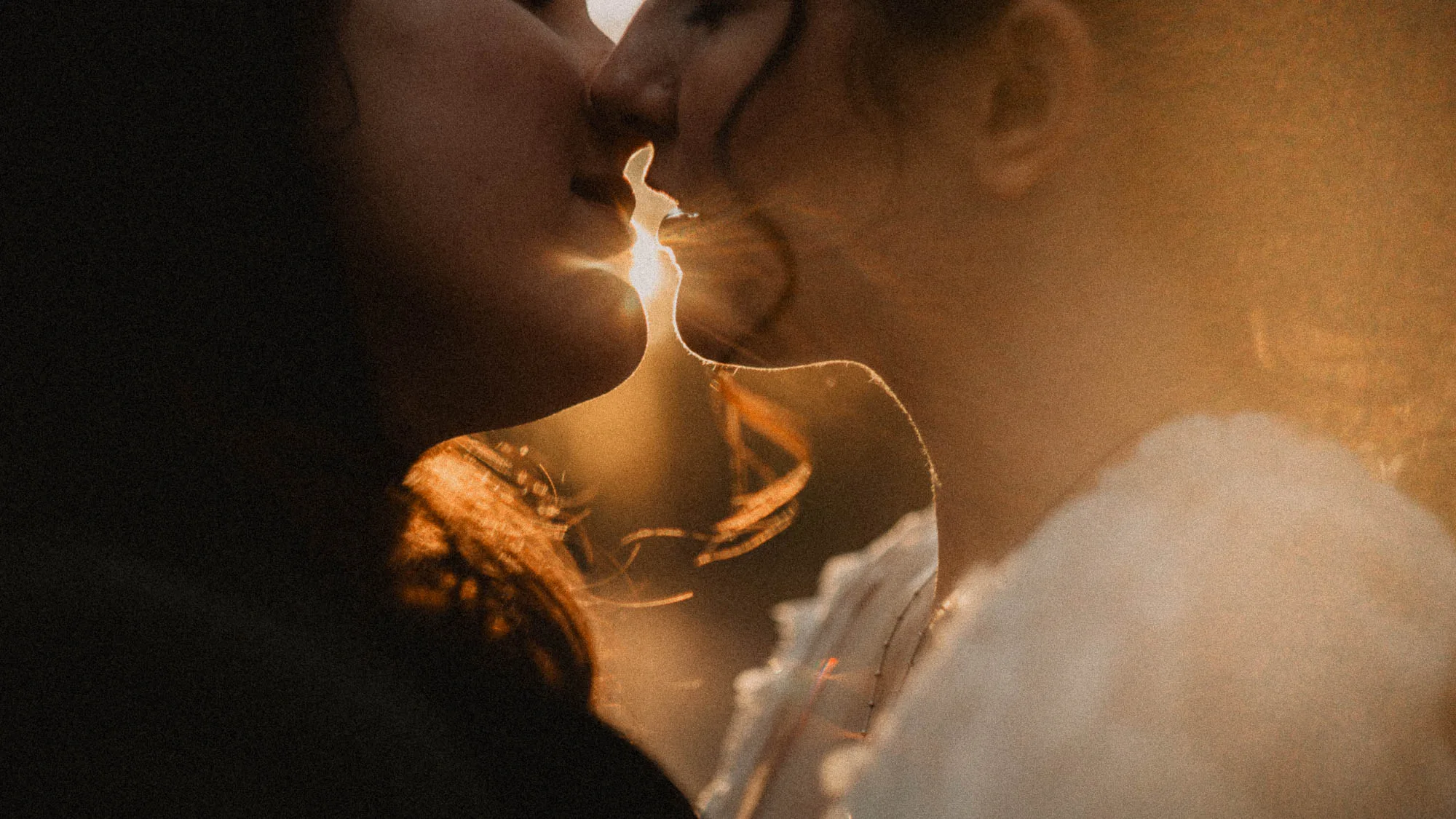An LGBTQ+ couple sharing a kiss during a dramatic, cinematic sunset at their micro wedding in the North Georgia mountains by Amanda Summerlin