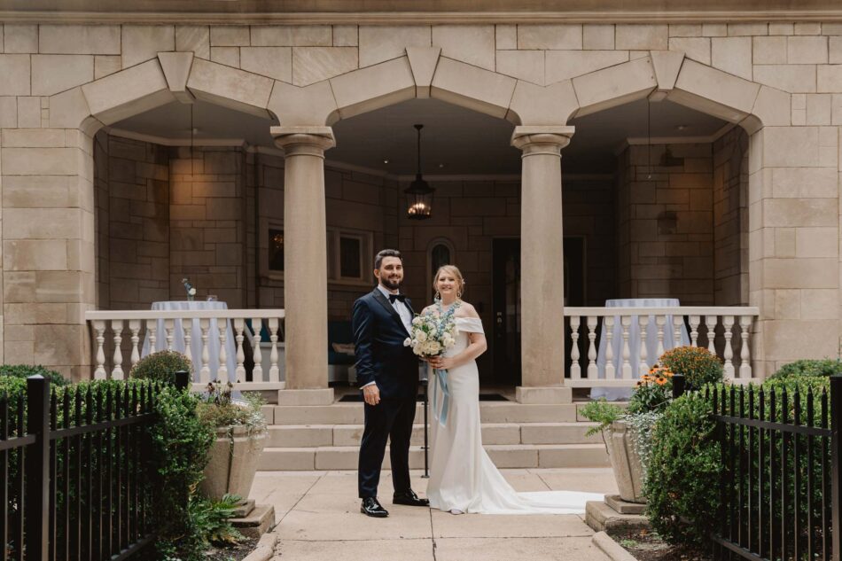A bride and a groom stand in front of Atlanta's historic Wimbish house on their wedding day
