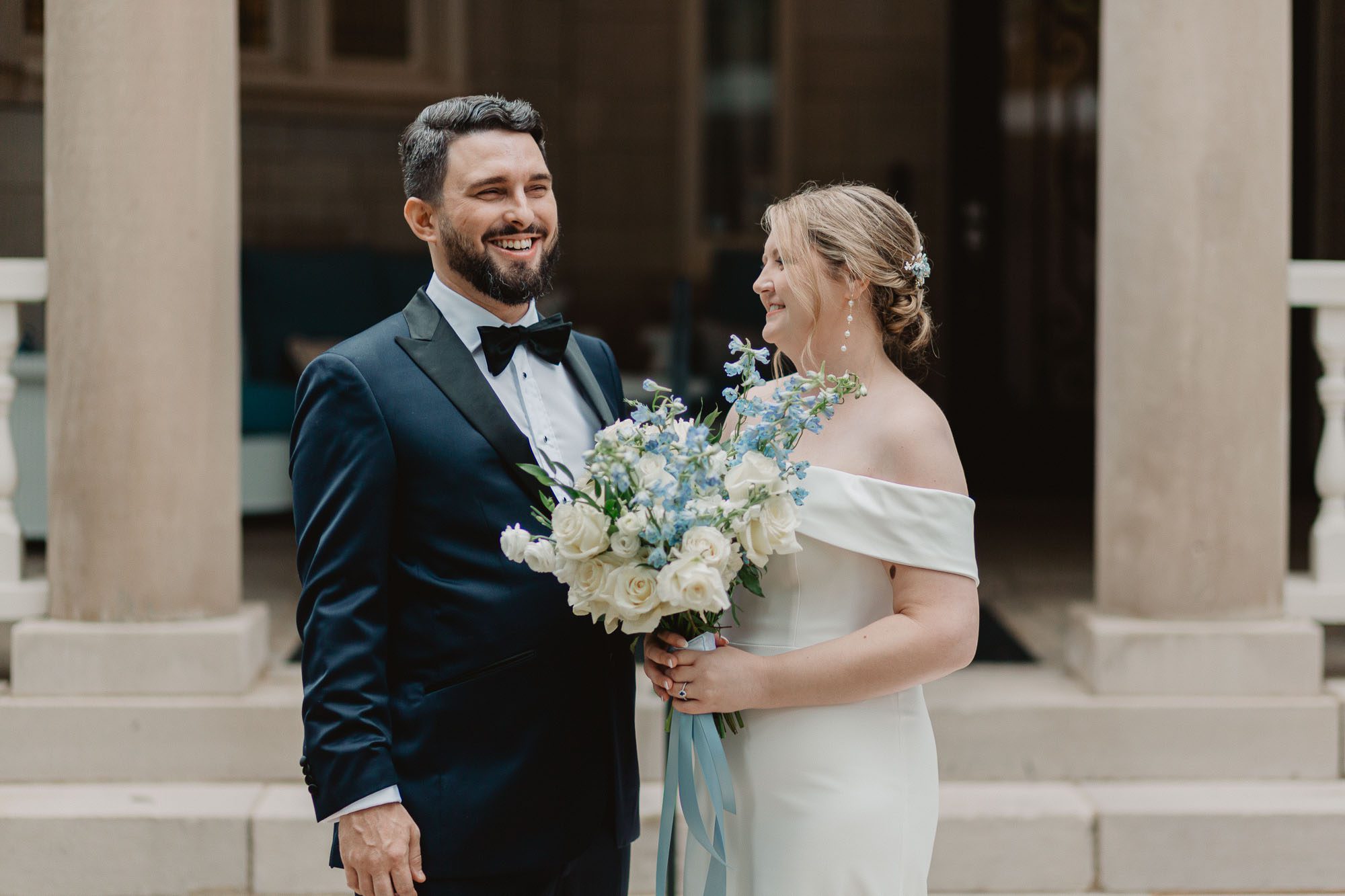 A bride and a groom laugh together as they stand in front of Atlanta's historic Wimbish house on their wedding day