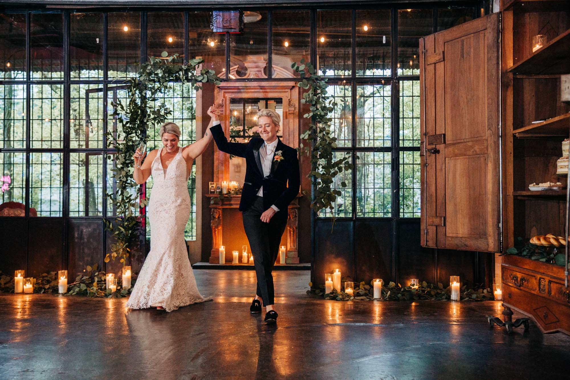 an lgbtq newlywed couple enters their candlelit wedding reception on their wedding day at Westside Warehouse in Atlanta