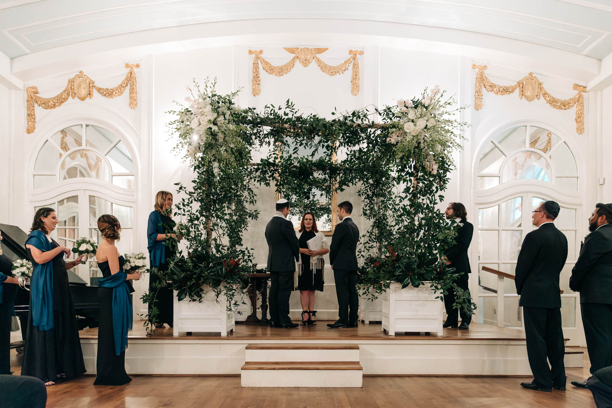 two men stand on the altar with their wedding party during their wedding in the ballroom of Atlanta's historic Wimbish House, an LGBTQ friendly wedding venue in Midtown