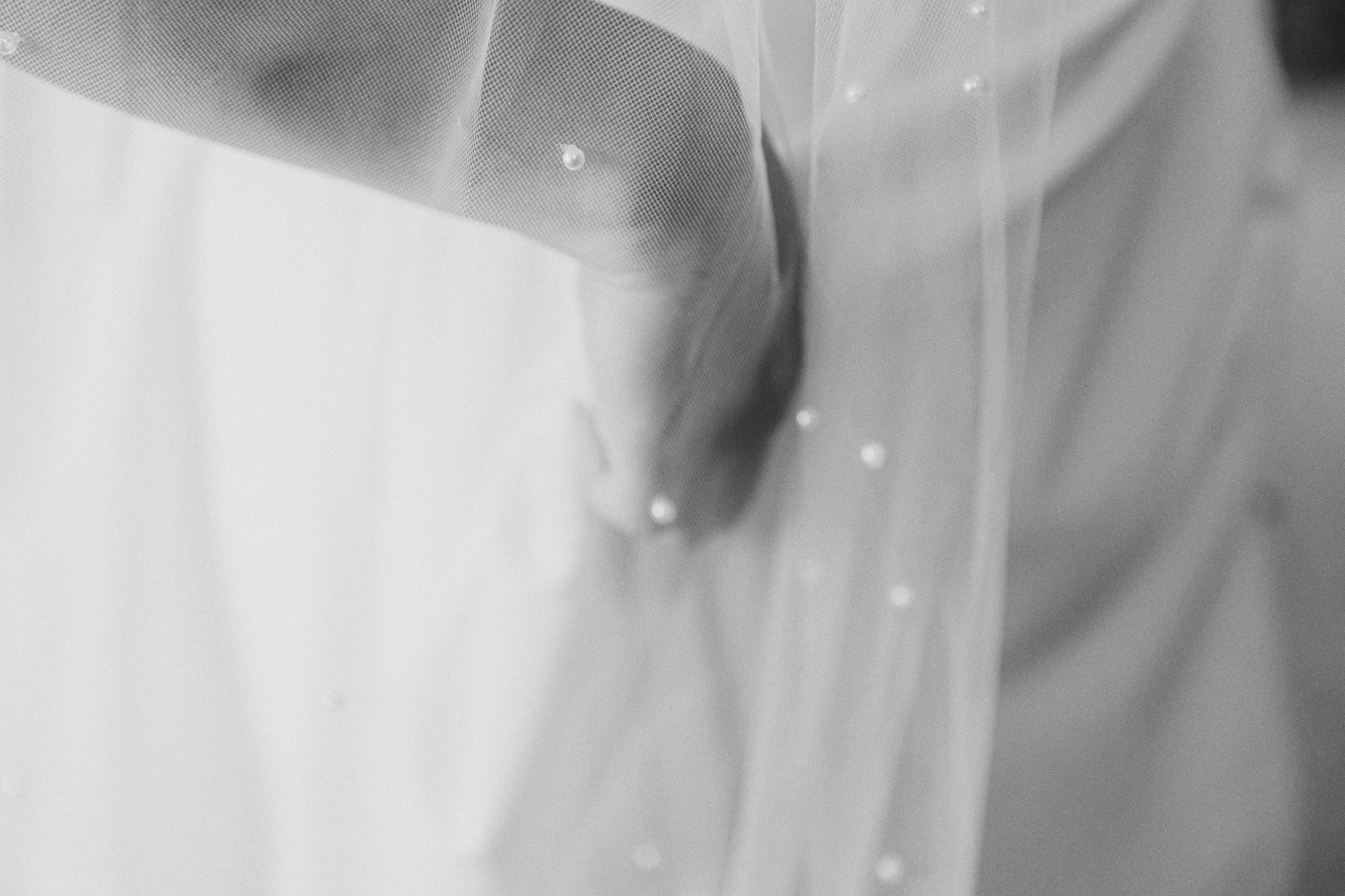 Close-up of the bride’s hands smoothing her veil before the ceremony.