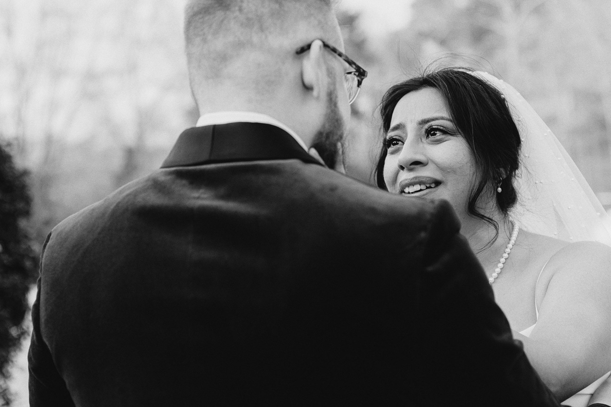 The groom laughs softly as the bride’s eyes well up with happy tears.