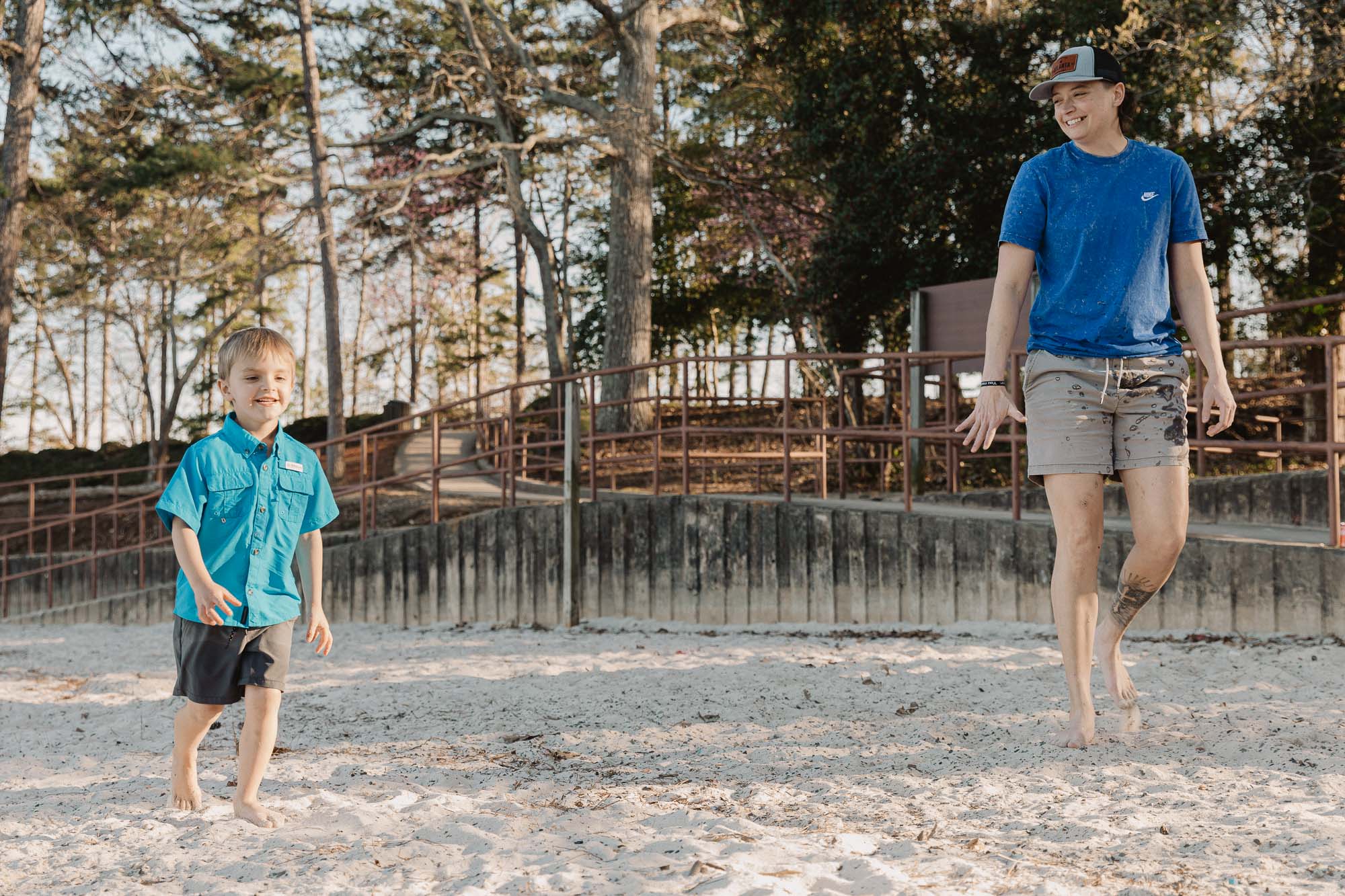 a mother walks beside her small child on the beach at Lake Lanier during their lifestyle family photo session in a photo by Atlanta family photographer Amanda Summerlin