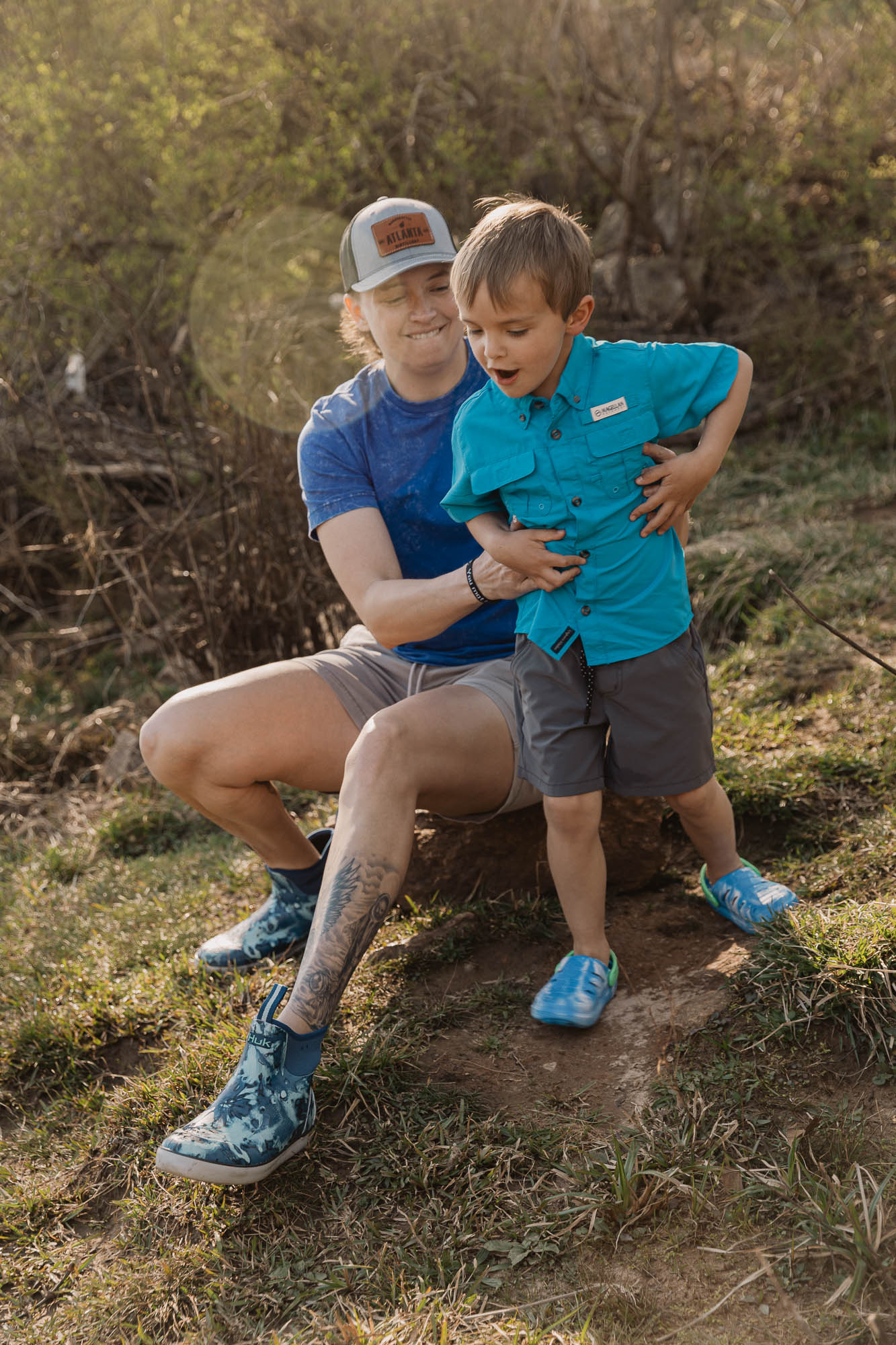 a small restless child wrestles his way out of his mother's grip