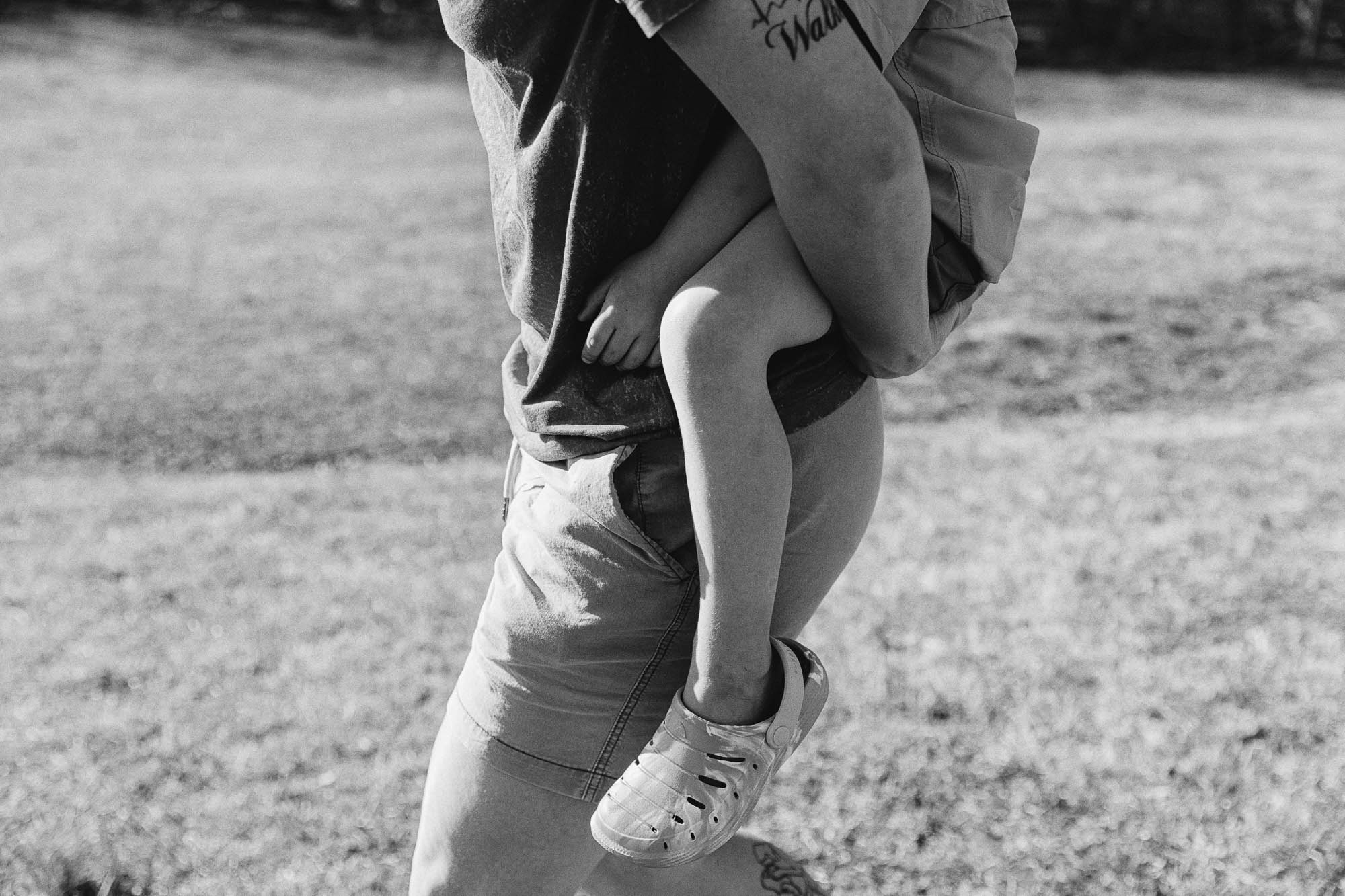 a mother carries her small child piggyback during their lifestyle family photo session in a photo by Atlanta family photographer Amanda Summerlin