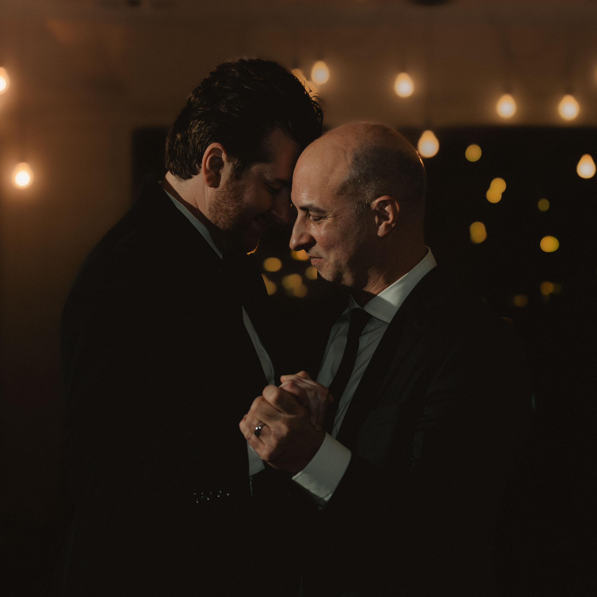 a gay male couple enjoy their first dance at their wedding reception at Upstairs Atlanta wedding venue