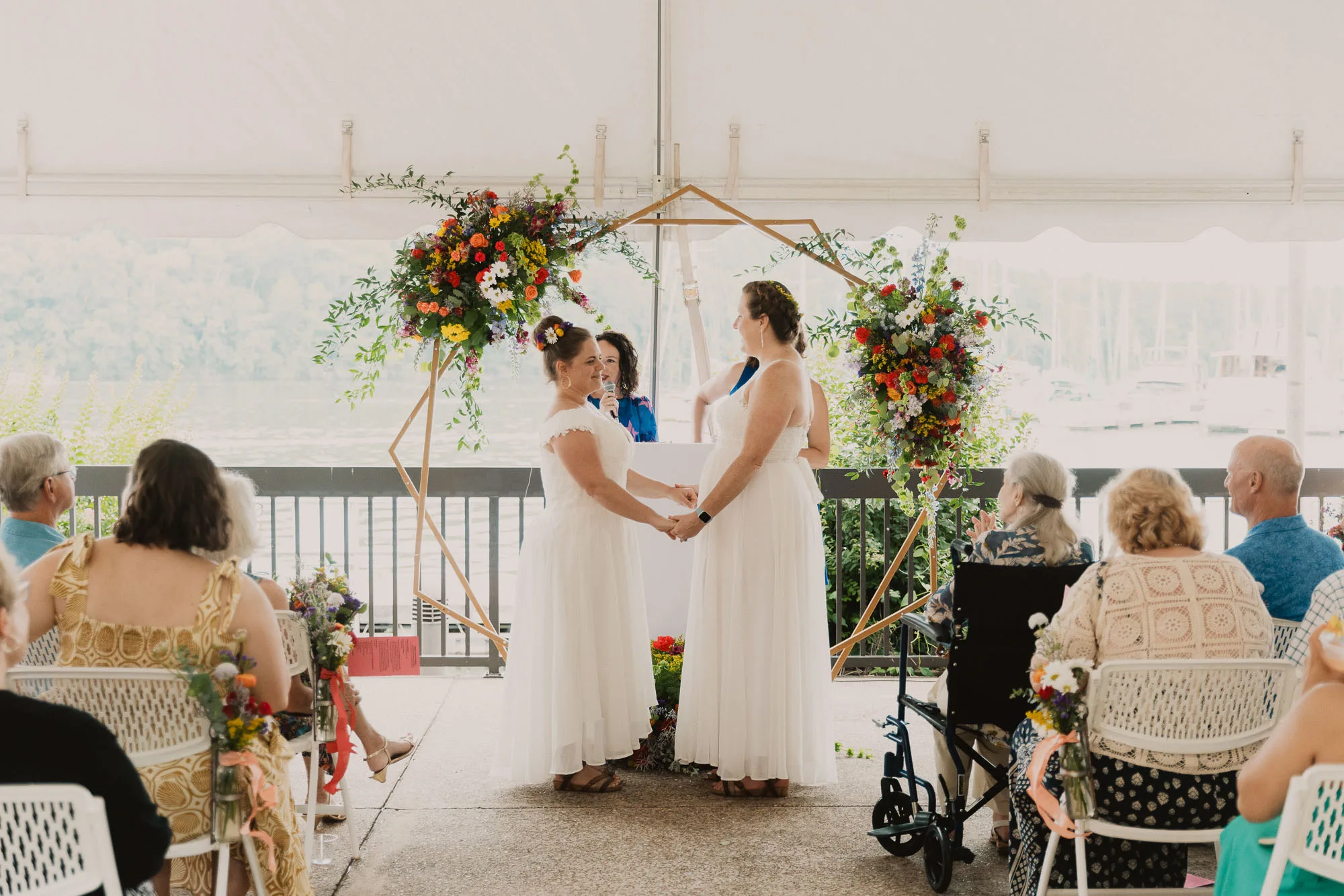 two brides wearing white dresses hold hands at the altar on their wedding day at Joe Wheeler State Park in northwest Alabama