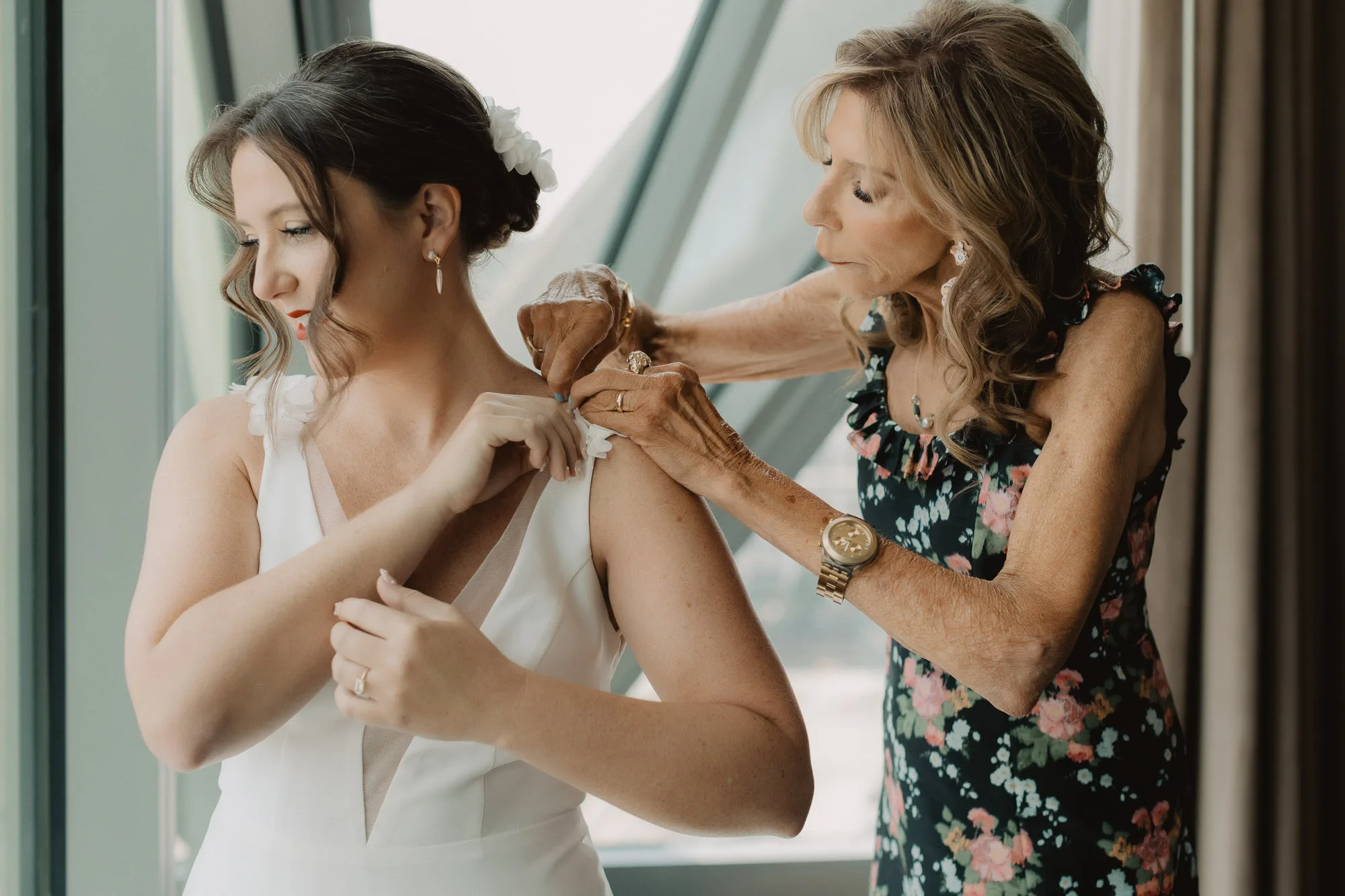 an atlanta bride gets ready with the help of her mom while standing in front of the hotel room window at Forth Hotel